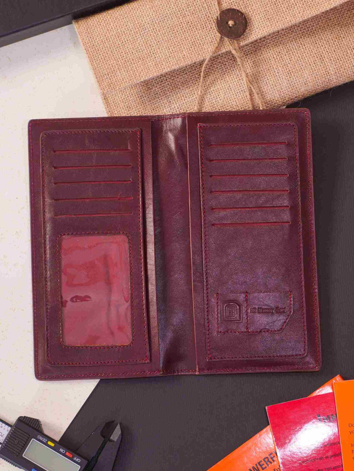 Elegant deep brown genuine leather long wallet open on a luxury flat lay setup