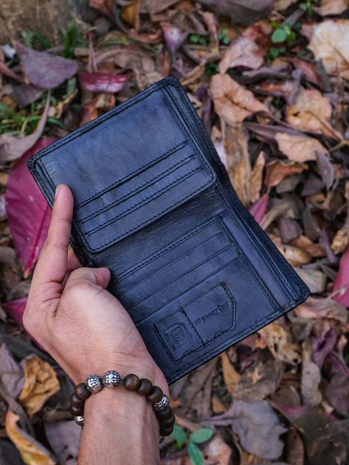 Open black leather vertical wallet showing extensive internal credit card slots and premium craftsmanship