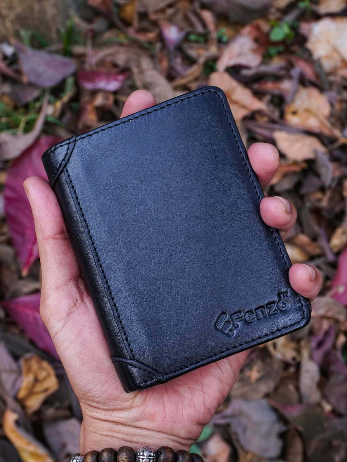 Handheld burgundy leather vertical compact wallet with multiple card compartments for a sleek aesthetic